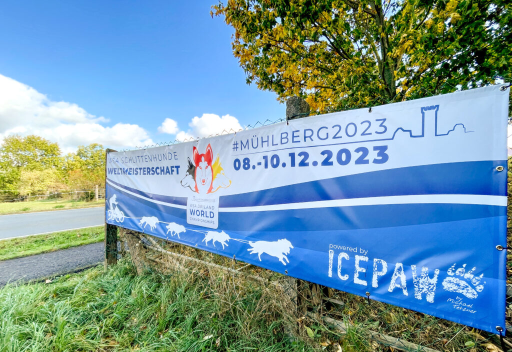 Ein Banner wirbt für die WSA-Dryland-Weltmeisterschaft für reinrassige nordische Schlittenhunde im Dezember 2023 in Mühlberg/Thüringen.